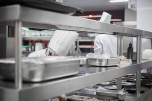 La limpieza de campanas extractoras seguro hosteleria es imprescindible, tal como hacen estos dos cocineros profesionales en restaurante bar